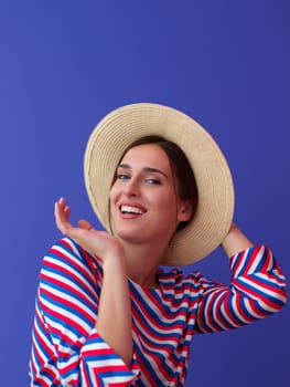 Portrait of young woman sitting on the chair isolated on purple background. Female model in casual and modern clothes posing in the studio