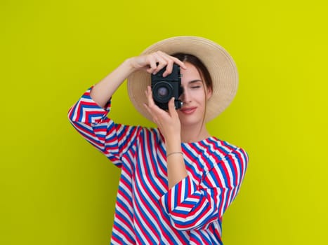 Portrait of beautiful female photographer shooting close up. Say cheese. Young smiling woman holding camera isolated on green background