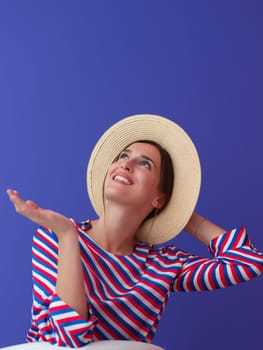 Portrait of young woman sitting on the chair isolated on purple background. Female model in casual and modern clothes posing in the studio