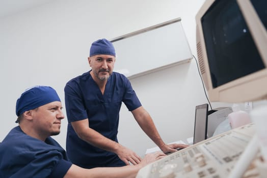 Orthopedist doctor team examining digital X-ray picture in clinic on a laptop computer. High quality photo. Selective focus