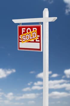 Left Facing Sold For Sale Real Estate Sign on a Blue Sky with Clouds.
