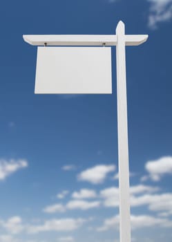 Blank Real Estate Sign Over A Blue Sky with Clouds.