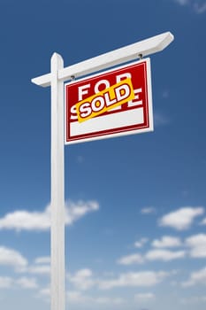 Right Facing Sold For Sale Real Estate Sign on a Blue Sky with Clouds.