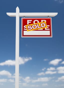 Right Facing Sold For Sale Real Estate Sign on a Blue Sky with Clouds.