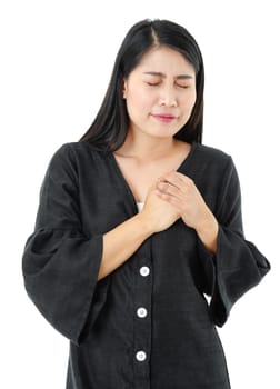 Young woman wearing black dress isolated on white background with hands on chest and feels painful gesture on face from heart attack. Health concept.