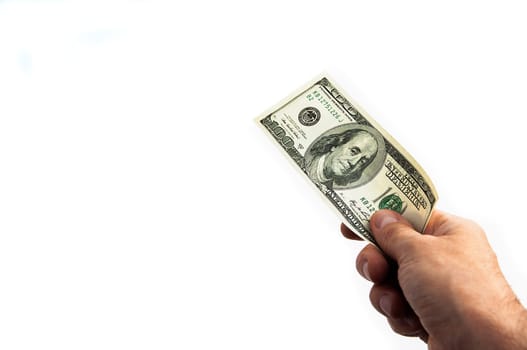 A hundred-dollar bill in his hand on a white background. Isolated. One hundred American dollars bill. One bill is dollars. The hand holds out the dollars. Place for logo, lettering, layout, layout.