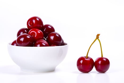 Cherry berries in a white cup on a white background. Isolated. Ripe cherries. Red delicious cherry. Place for advertising, lettering, logo, text, layout, mockup.