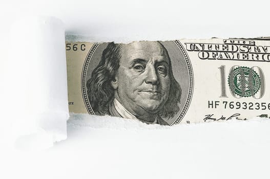 The face of Benjamin Franklin on a hundred-dollar bill, from a torn window in white paper. Background, white. Isolated. Close-up. A hundred-dollar American bill with the eyes of Benjamin Franklin. Color style. Place for logo, lettering, sign, template, mockup.