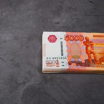 Russian rubles a large bundle on a gray background. A bundle of five-thousand-ruble notes. Place for logo, text, layout, mockup.