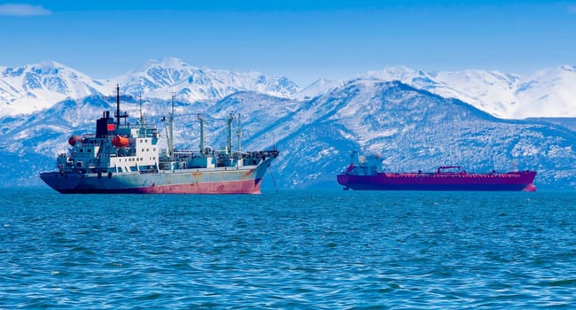 The large fishing vessel on the background of hills and volcanoes. Selective focus
