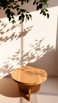 A simple wooden table with a round top filled with a coating that provides sunlight. The delicate shadows of leafy branches play on the textured cream wall in the background. High quality photo