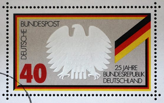 A stamp printed in Germany shows Federal Eagle and Flag, 25 years Federal Republic of Germany, circa 1974