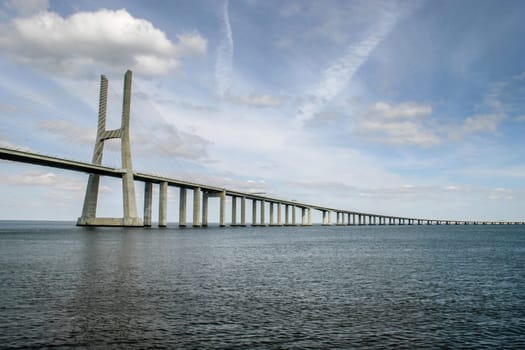 Lisbon, Portugal - September 18, 2006:  Vasco da Gama Bridge over Tagus River with dramatic clouds in background. Bridge was opened for Expo 98