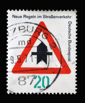 Stamp printed in Germany dedicated to New traffic rules, shows a road sign "Proceed with caution"", circa 1971"