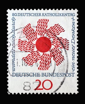 Stamp printed in Germany showing a stylized sun with inscription: walk through a new way of thinking. German Catholic Day in Stuttgart, circa 1964