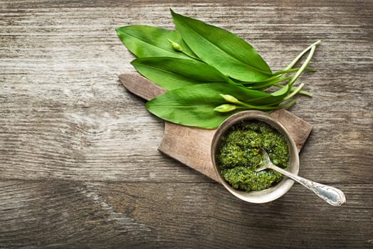 Wild garlic pesto on wood table closeup