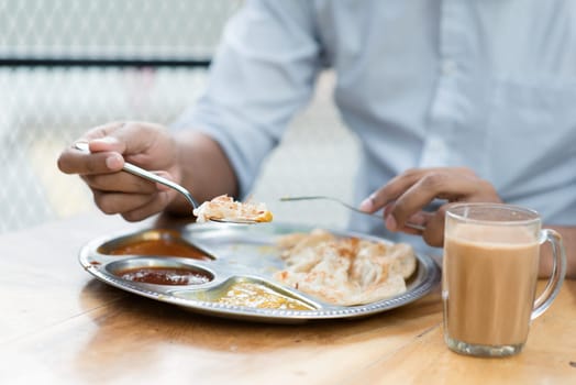 Man having Indian meal at cafeteria.