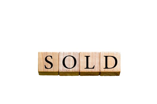 Word SOLD. Wooden small cubes with letters isolated on white background with copy space available. Concept image.