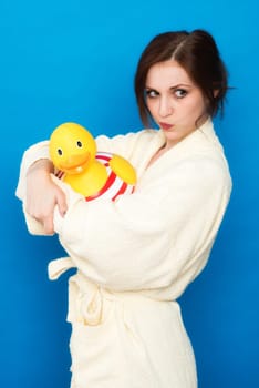 Woman in bathrobe wears a large bath duck