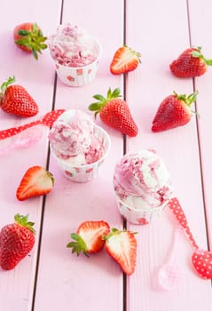 Milk ice cream with fresh strawberries on pink rustic background