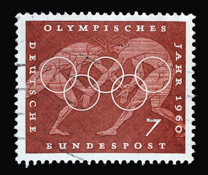 Stamp printed in Germany showing Wrestling, Sport Scene from Greek vase paintings, Olympic rings and promotes 17th Olympic Games in Rome, circa 1960