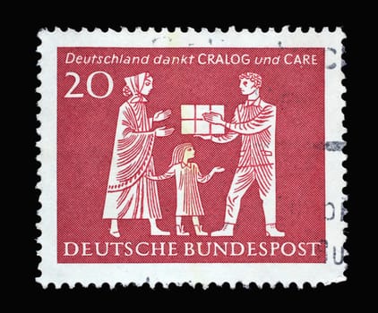 Stamp printed in Germany shows Mother and Child Receiving Gift Parcel, in gratitude for American help during 1946-1962, circa 1963
