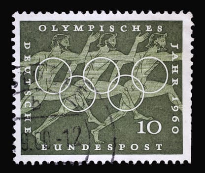 Stamp printed in Germany showing Running, Sport Scene from Greek vase paintings, Olympic rings and promotes 17th Olympic Games in Rome, circa 1960
