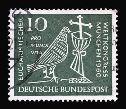 Stamp printed in Germany showing a stylized dove, cross and chalice. 37th Eucharistic World Congress in Munich, circa 1960