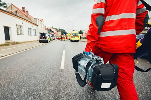 Hand of the doctor with defibrillator. Teams of the Emergency medical service are responding to an traffic accident.