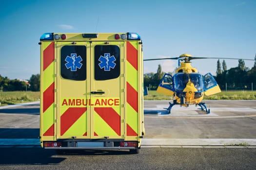 Ambulance car against helicopter of emergency medical service. Themes rescue, help and hope.