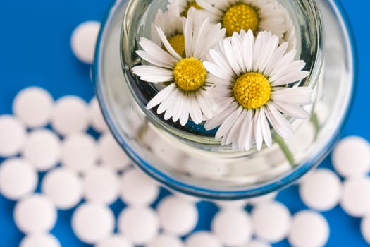 Homeopathic medication, focus on flower, ower blue background