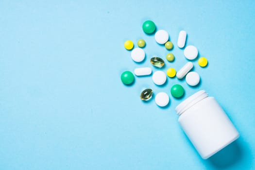 Pharmaceutical medical Pills, tablets and capsules on blue background top view. Medical pharmacy concept.