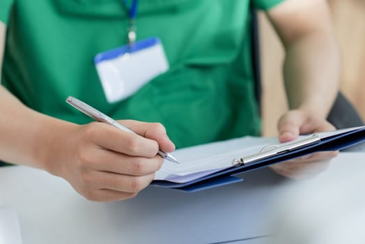 Close-up image of doctor filling medical history of patient