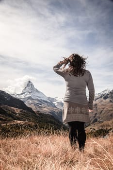 Young woman enjoying a view in the mountains near Swiss resort town of Zermatt
