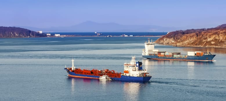 The Large container ship and reefer ship at blue sea. Selective focus
