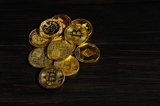 Leader in cryptocurrency bitcoin BTC on a top of coins against black wooden surface. Closeup golden coin with bitcoin logo. Stack of decentralized digital currency. Crypto payment. Electronic money