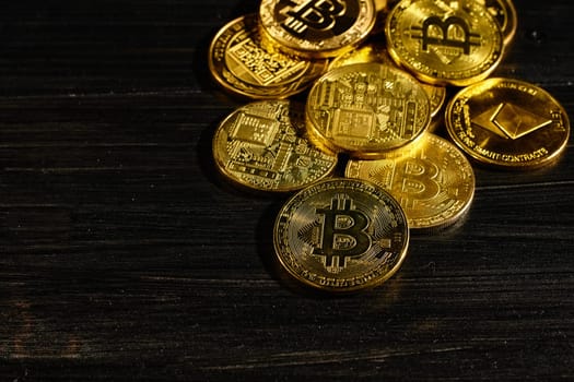Leader in cryptocurrency bitcoin BTC on a top of coins against black wooden surface. Closeup golden coin with bitcoin logo. Stack of decentralized digital currency. Crypto payment. Electronic money