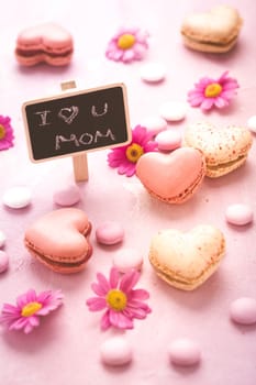 Happy Mothers Day - sweet macarons in heart shape with flowers in pink tone with text I love you Mum