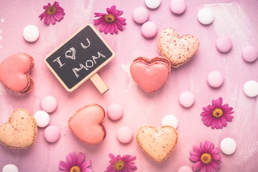 Happy Mothers Day - sweet macarons in heart shape with flowers in pink tone