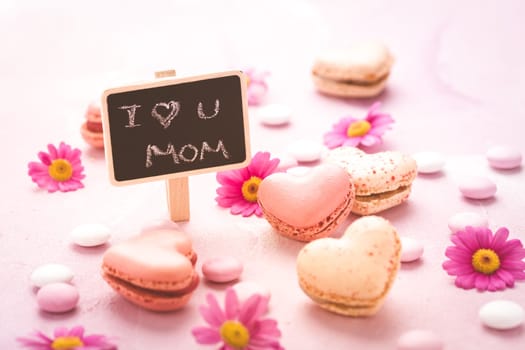 Happy Mothers Day - sweet macarons in heart shape with flowers in pink tone with text I love you Mum
