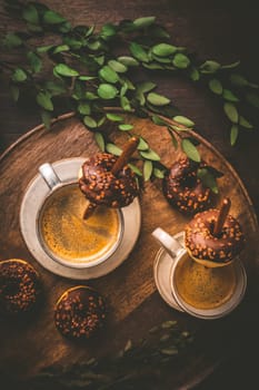 Coffee time - two cups of Caffe Americano with small chocolate donuts