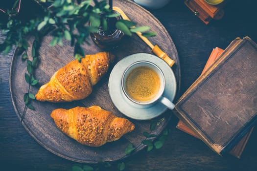 Breakfast - Croissants with nuts and cup of coffee on morning table