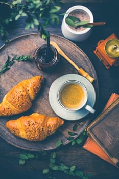 Breakfast - Croissants with nuts and cup of coffee on morning table