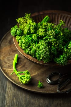 Organic Broccolini (bimi) in bowl on wooden background