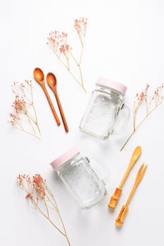 Empty drinking cups or jars with wooden spoons on white background. Plastic free lifestyle and concept