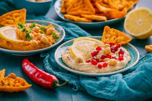 Homemade spicy humus with pomegranate seeds, chilli and chickpeas tortilla chips