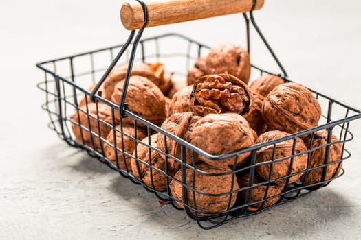 Organic walnuts in basket on kitchen table.