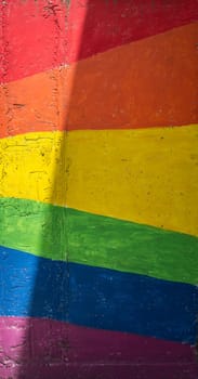 Concrete wall painted with rainbow colors. Symbol of LGBTQ Pride