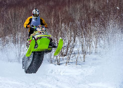 The Snowmobile in high jump above track. Selective focus
