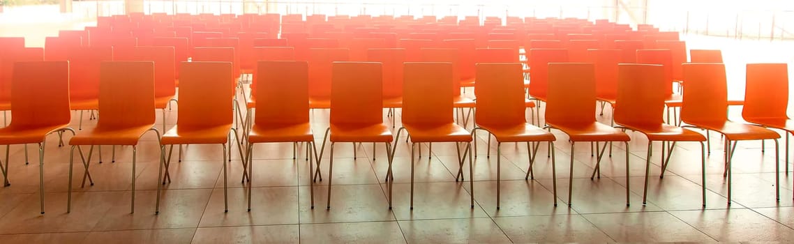 The Conference room with red chairs, concrete floor and windows. Selective focus